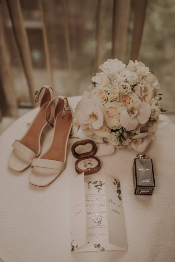 Elegant display of bridal shoes, bouquet, and wedding invitation on a table.